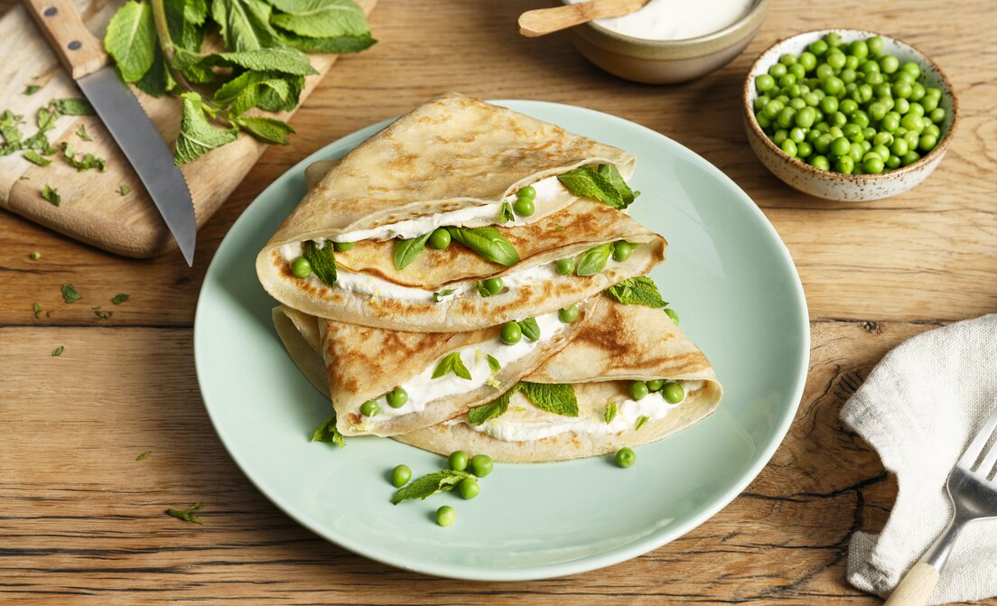Pannenkoeken met crème fraiche, doperwten en verse kruiden