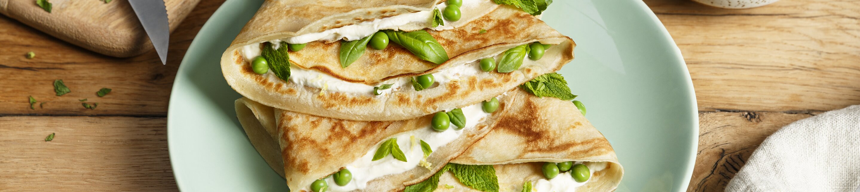 Pannenkoeken met crème fraiche, doperwten en verse kruiden
