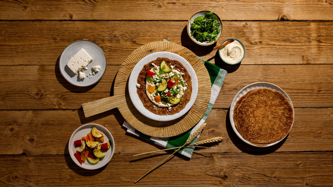 Volkoren pannenkoeken met hummus, gegrilde groenten en feta
